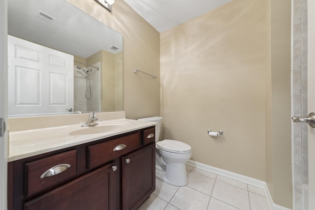 bathroom featuring a tile shower, vanity, tile patterned floors, and toilet