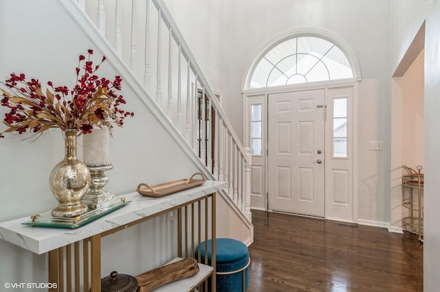 entryway featuring dark wood-type flooring and a high ceiling