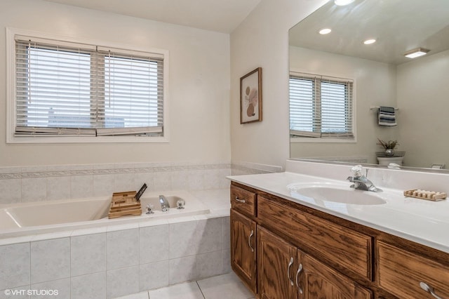 bathroom featuring toilet, vanity, tiled bath, and tile patterned flooring