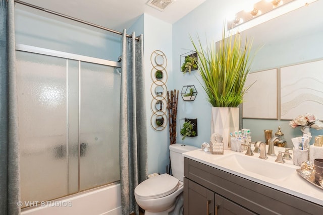 full bathroom featuring vanity, enclosed tub / shower combo, and toilet