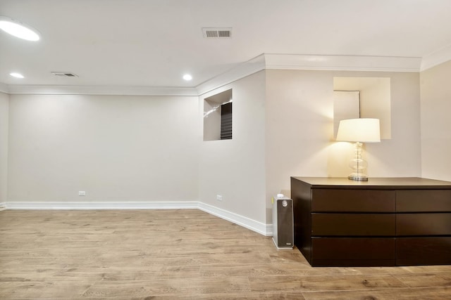 interior space featuring ornamental molding and light wood-type flooring