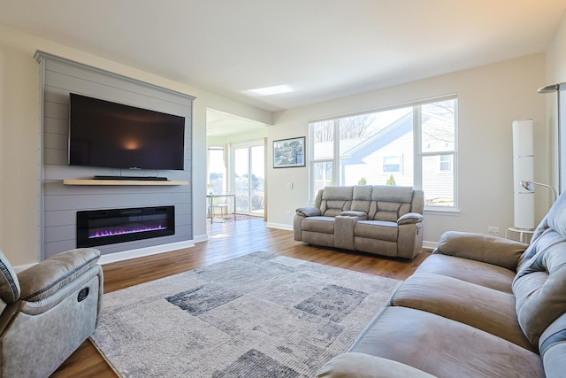 living room with a large fireplace and light wood-type flooring