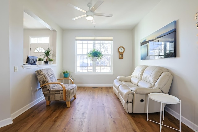 sitting room with dark wood-type flooring and ceiling fan