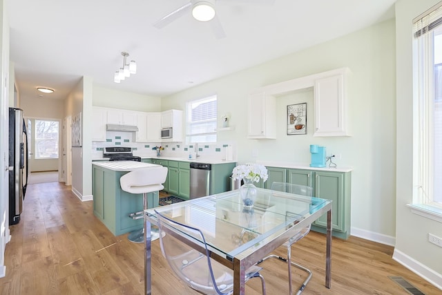 kitchen featuring a kitchen island, white cabinetry, appliances with stainless steel finishes, and green cabinetry