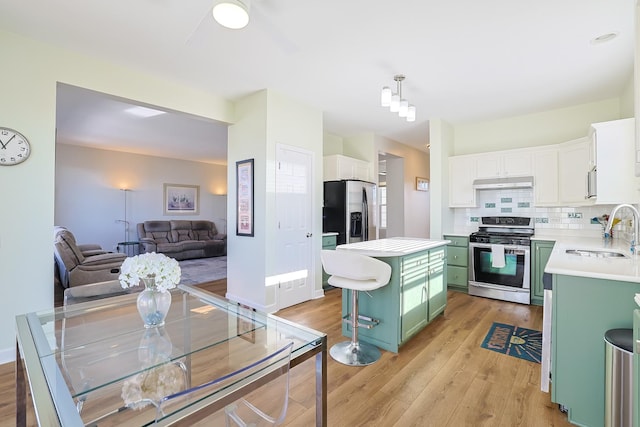 kitchen featuring sink, white cabinetry, stainless steel appliances, green cabinetry, and a kitchen island