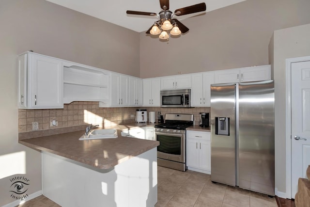 kitchen featuring white cabinetry, decorative backsplash, kitchen peninsula, and appliances with stainless steel finishes