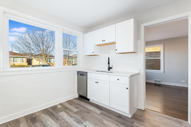 kitchen with dishwasher, sink, white cabinets, and light hardwood / wood-style flooring