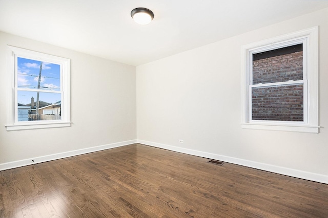 empty room with dark hardwood / wood-style flooring