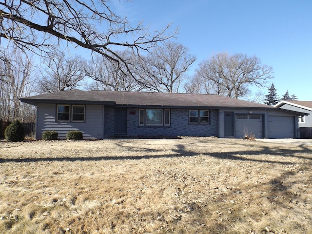 single story home with a garage and a front lawn