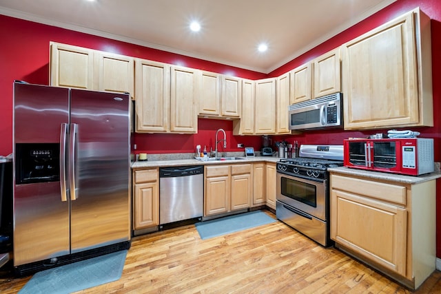 kitchen featuring sink, appliances with stainless steel finishes, ornamental molding, light hardwood / wood-style floors, and light brown cabinets