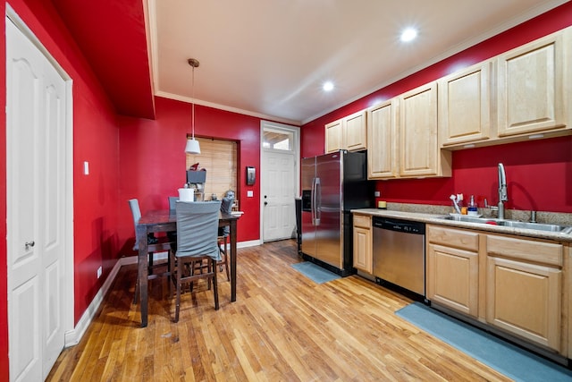 kitchen with pendant lighting, sink, ornamental molding, light hardwood / wood-style floors, and stainless steel appliances