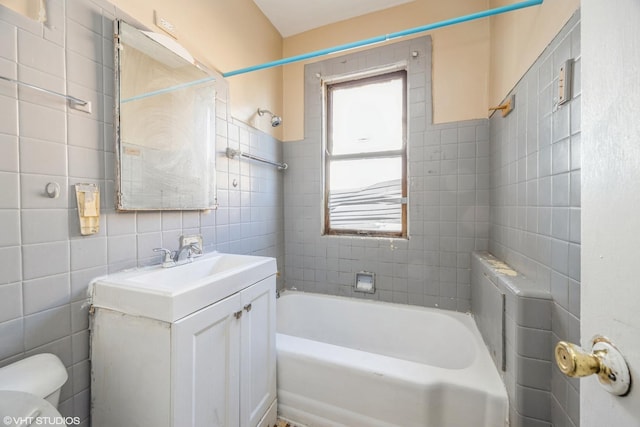 full bathroom with tiled shower / bath, tasteful backsplash, tile walls, vanity, and toilet