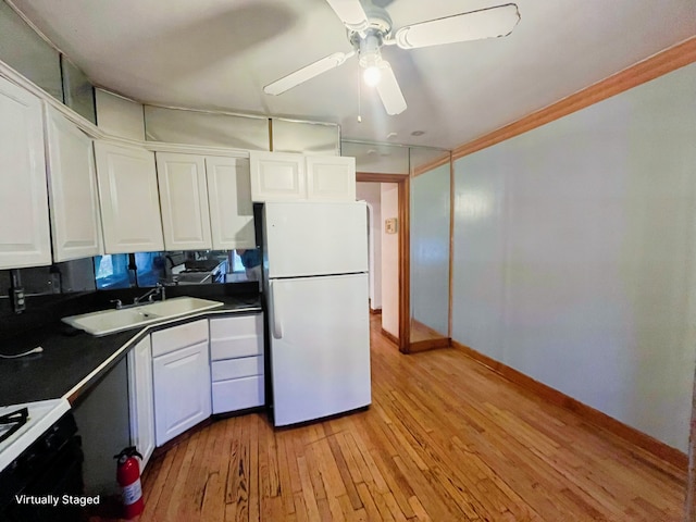 kitchen featuring sink, white cabinets, white fridge, range, and light wood-type flooring