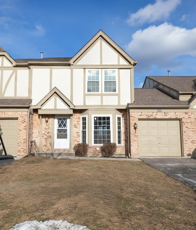 english style home with a garage and a front lawn