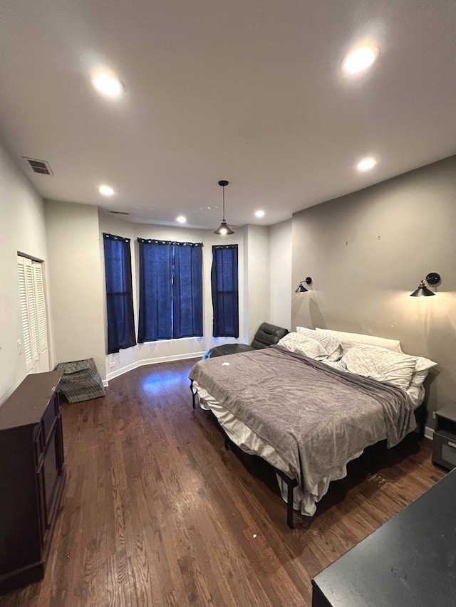 bedroom with dark hardwood / wood-style flooring and a closet