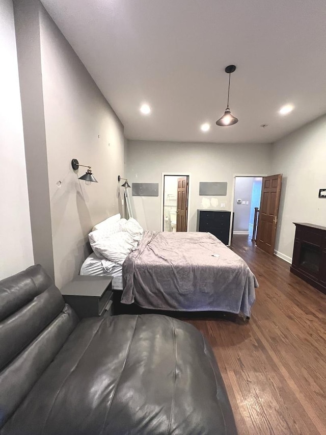 bedroom with a fireplace and dark wood-type flooring