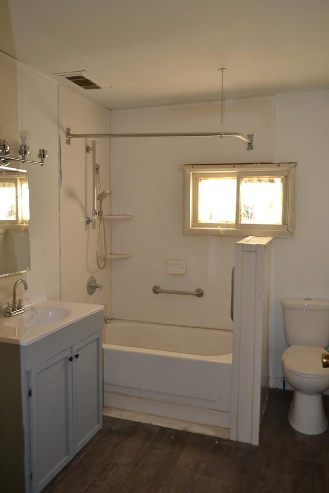 full bathroom with washtub / shower combination, vanity, toilet, and hardwood / wood-style floors