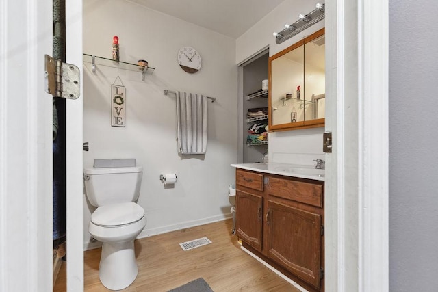 bathroom featuring vanity, hardwood / wood-style floors, and toilet