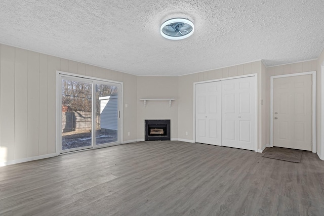 unfurnished living room featuring hardwood / wood-style floors and a textured ceiling