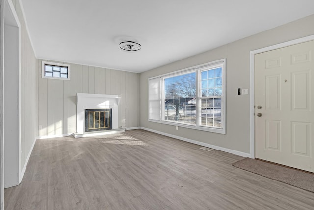 unfurnished living room with plenty of natural light and light hardwood / wood-style flooring