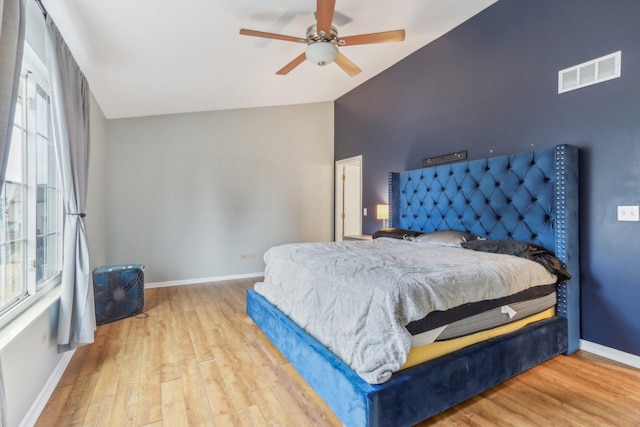 bedroom with ceiling fan, lofted ceiling, and light hardwood / wood-style flooring