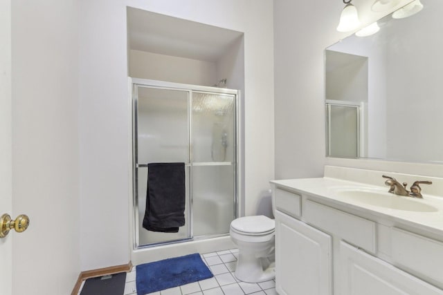 bathroom featuring vanity, a shower with door, tile patterned floors, and toilet