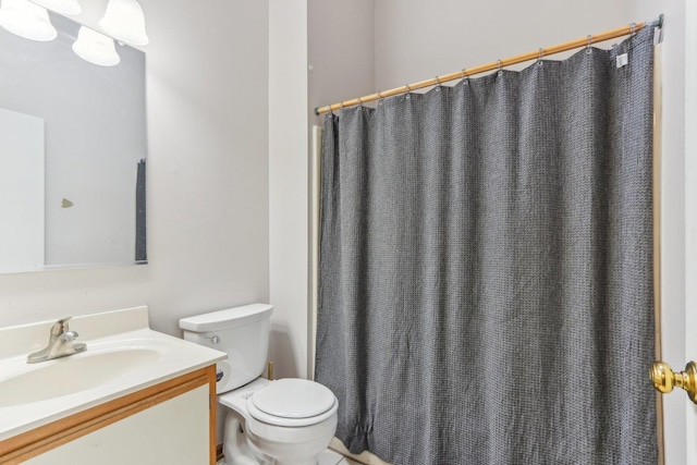 bathroom featuring walk in shower, vanity, and toilet