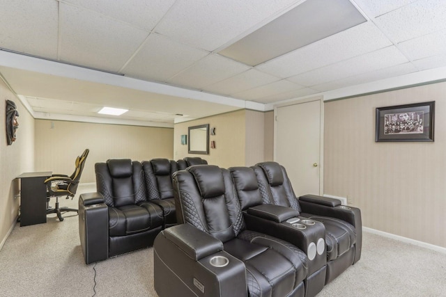 carpeted home theater room featuring a drop ceiling