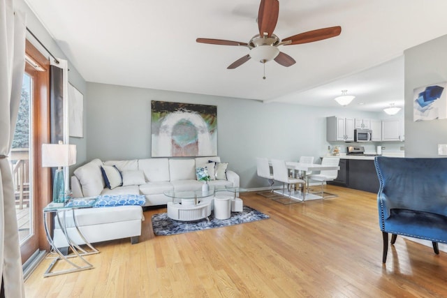 living room featuring ceiling fan and light wood-type flooring