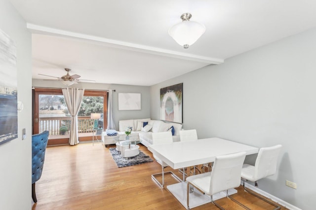 dining space featuring beam ceiling, light hardwood / wood-style flooring, and ceiling fan