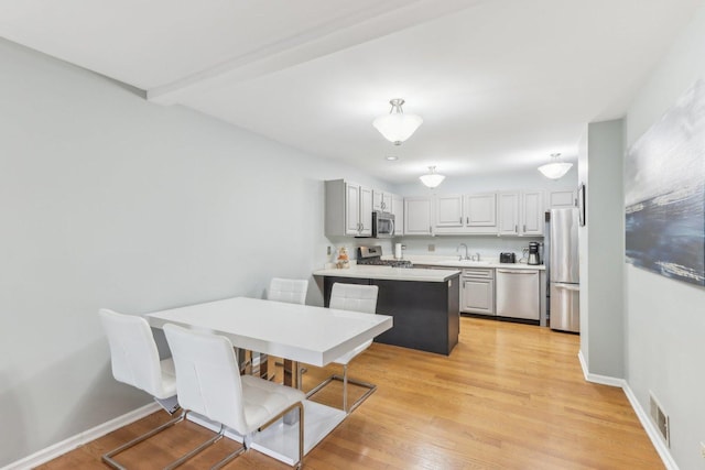 dining area with sink and light hardwood / wood-style floors