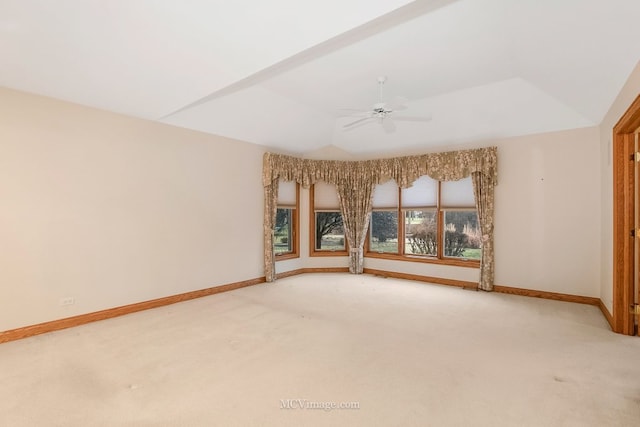 spare room featuring lofted ceiling, a raised ceiling, ceiling fan, and carpet