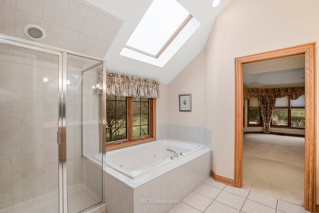 bathroom with a healthy amount of sunlight, tile patterned floors, independent shower and bath, and vaulted ceiling with skylight