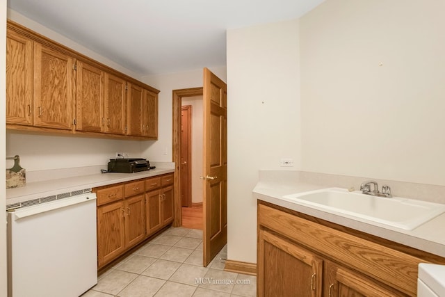 kitchen with sink, light tile patterned floors, and dishwasher