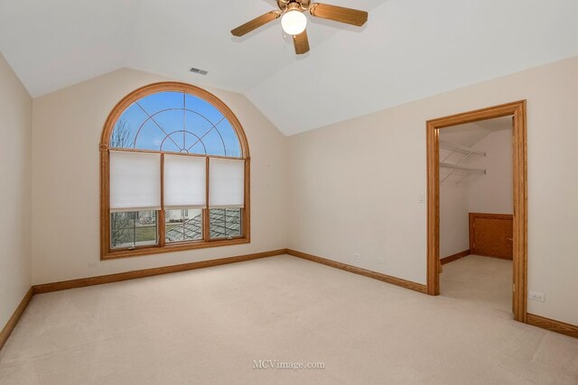 carpeted empty room with lofted ceiling and ceiling fan