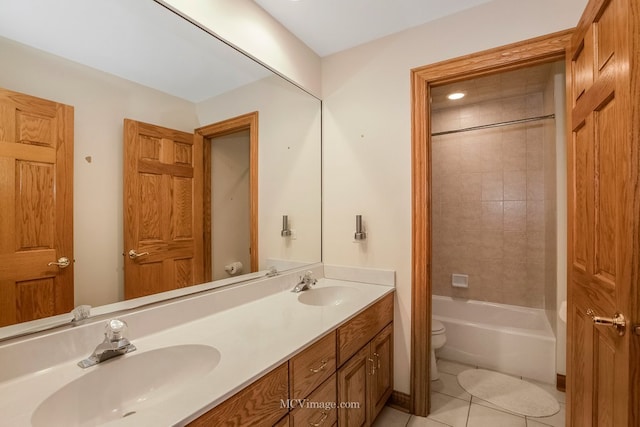 full bathroom featuring tiled shower / bath combo, vanity, tile patterned floors, and toilet