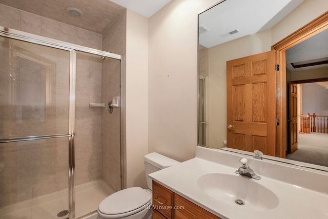 bathroom featuring toilet, vanity, and a shower with shower door