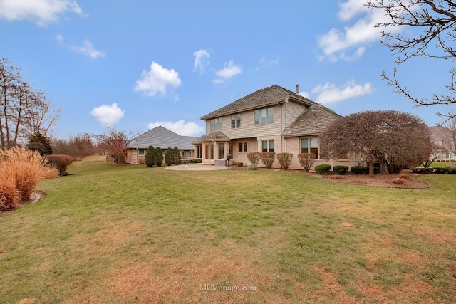 back of property featuring a patio area and a lawn