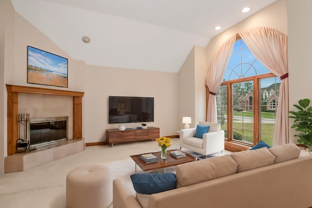 living room with high vaulted ceiling, light carpet, and a tile fireplace