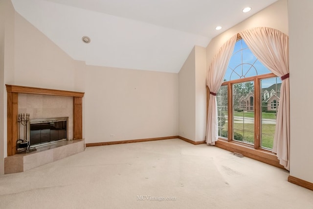 unfurnished living room with a fireplace, vaulted ceiling, and carpet flooring