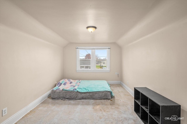 bedroom featuring vaulted ceiling and light colored carpet