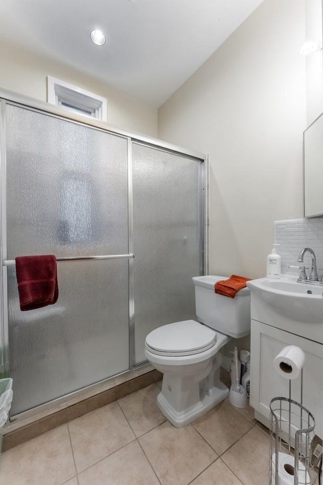 bathroom with tile patterned flooring, toilet, backsplash, and walk in shower