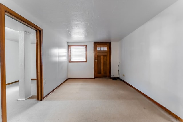 foyer with light colored carpet and a textured ceiling