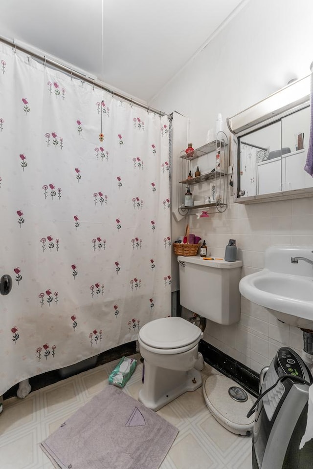 bathroom featuring a shower with shower curtain, toilet, sink, and tile walls