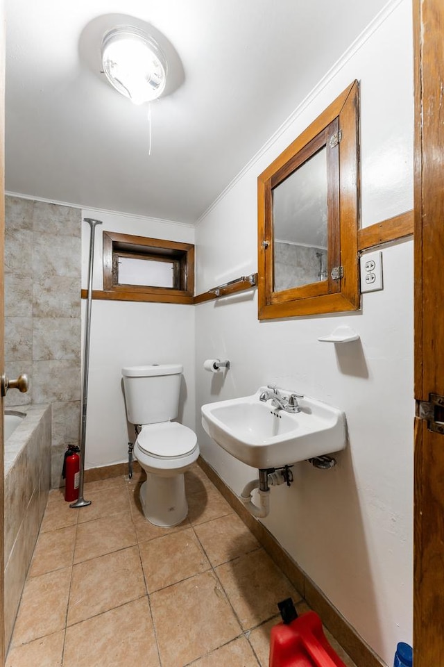 bathroom with sink, crown molding, tiled bath, tile patterned floors, and toilet