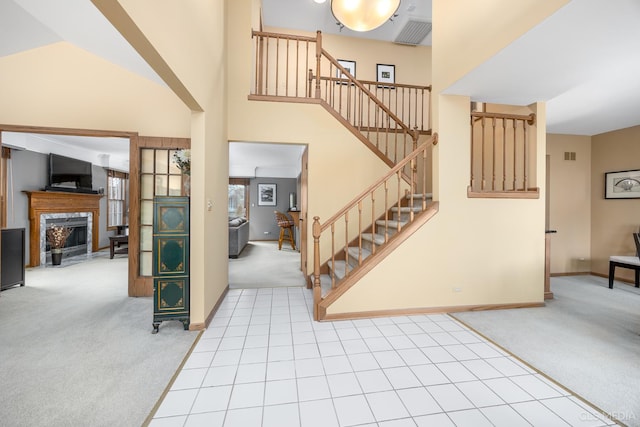 carpeted entrance foyer featuring a towering ceiling