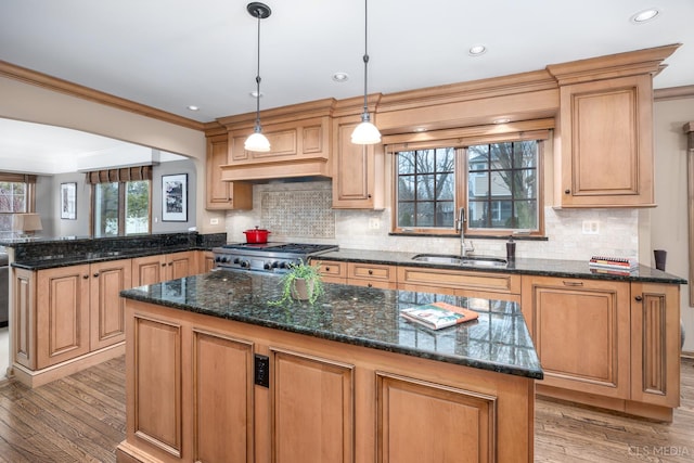 kitchen with sink, hanging light fixtures, a center island, and range