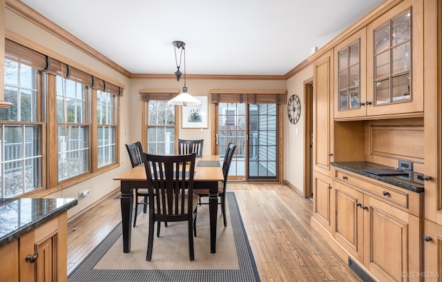 dining area featuring crown molding and light wood-type flooring