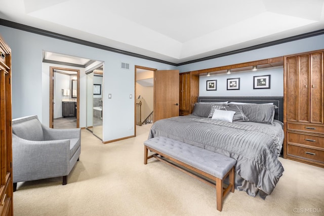 carpeted bedroom featuring a raised ceiling, crown molding, and ensuite bath