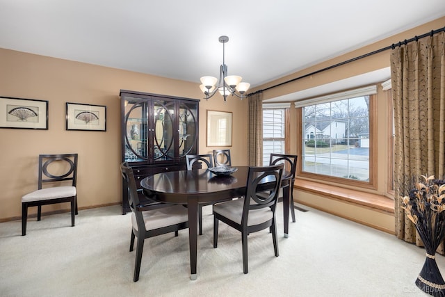 dining area with an inviting chandelier and light colored carpet